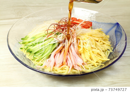 冷やし中華ラーメン、ラーメンにたれをかける 冷やし中華ラーメン、ラーメンにたれをかける 73749727