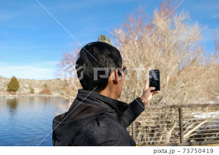 travel man use smart phone o taking photo of the beautiful mountain landscape. 73750419
