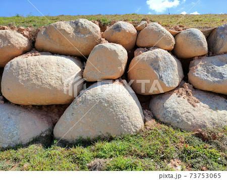 Natural boulders are used as retaining walls of ground banks that have been embanked. Other slopes are planted with grass to prevent erosion caused by rain. 73753065