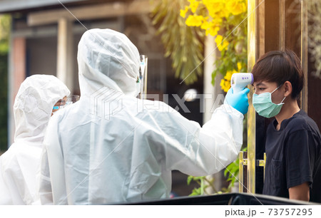 Proactive home health nurse takes the Temperature Measurement check scanner to monitor in hand at local Thaiand 73757295
