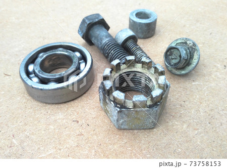 Used bearings, gaskets, screws and some other mechanical components of engines isolated on the high-pressure timber board. Used bearings, gaskets, screws and some other mechanical components of engines isolated on the high-pressure timber board. 73758153