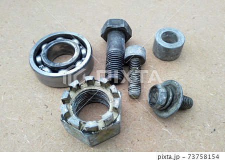 Used bearings, gaskets, screws and some other mechanical components of engines isolated on the high-pressure timber board. Used bearings, gaskets, screws and some other mechanical components of engines isolated on the high-pressure timber board. 73758154