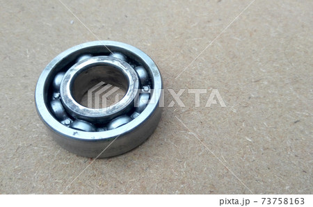 Used bearings, gaskets, screws and some other mechanical components of engines isolated on the high-pressure timber board.  73758163