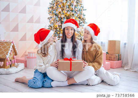 Young mom with kids holding christmas presents Young mom with kids holding christmas presents 73758566