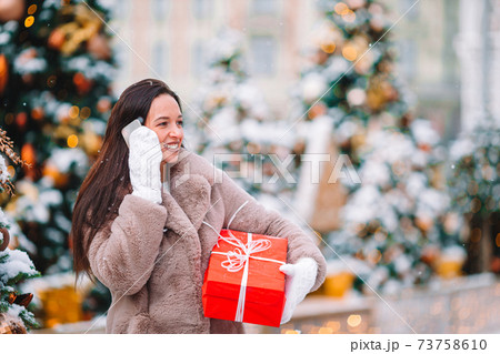Happy girl near fir-tree branch in snow for new year. 73758610