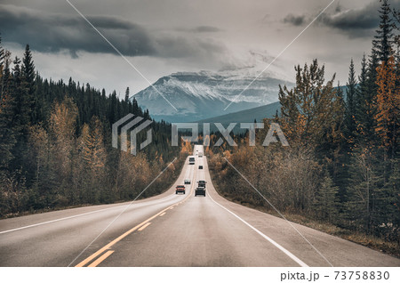 Car driving on the road in autumn forest and rocky mountains in Jasper national park Car driving on the road in autumn forest and rocky mountains in Jasper national park 73758830