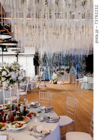 The presidium of the newlyweds in the banquet hall of the restaurant is decorated with candles and green plants 73762232