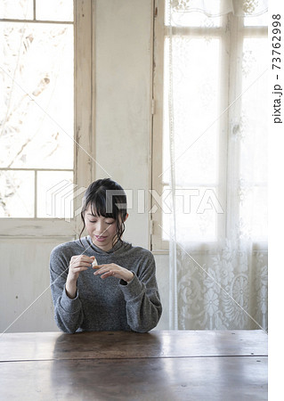 指に絆創膏を貼る女性 73762998