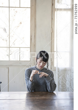 指に絆創膏を貼る女性 73762999