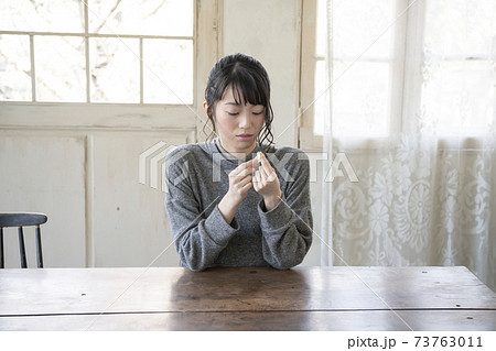 指に絆創膏を貼る女性 指に絆創膏を貼る女性 73763011