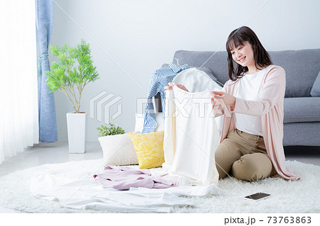 洋服の片付けをする若い女性　断捨離　衣替え 73763863