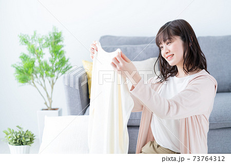 洋服の片付けをする若い女性　断捨離　衣替え 73764312