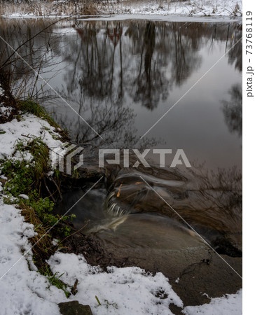 Water reflections of trees in a river. Picture from Eslov, Sweden Water reflections of trees in a river. Picture from Eslov, Sweden 73768119