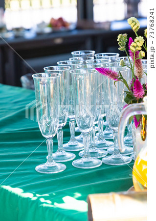 set of wine glass long stands on a green tablecloth on a blurred background set of wine glass long stands on a green tablecloth on a blurred background 73768241