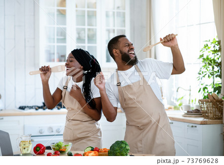 Kitchen Concert. Cheerful Black Couple Having Fun While Cooking Together At Home Kitchen Concert. Cheerful Black Couple Having Fun While Cooking Together At Home 73769628