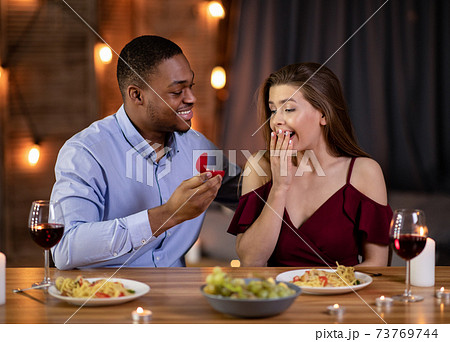 Marriage Proposal. Romantic Black Boyfriend Proposing Girlfriend To Marry Him In Restaurant Marriage Proposal. Romantic Black Boyfriend Proposing Girlfriend To Marry Him In Restaurant 73769744