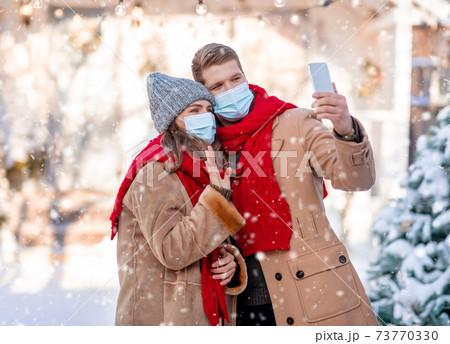 Man and his girlfriend taking photo on beautiful snowy day 73770330