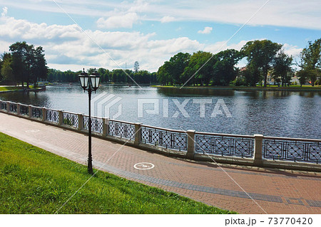 Pedestrian sidewalk around city lake embankment Pedestrian sidewalk around city lake embankment 73770420