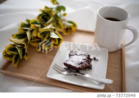 木製のトレイに乗っている、コーヒーとチョコレートケーキ 73772049