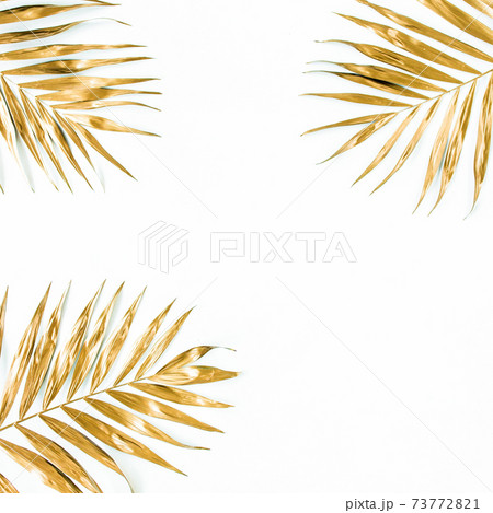 Gold tropical palm leaves on white background. Flat lay, top view minimal concept. Gold tropical palm leaves on white background. Flat lay, top view minimal concept. 73772821