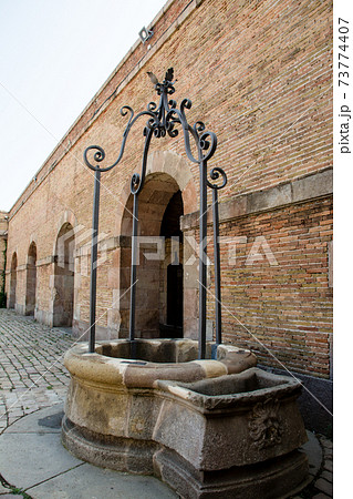 スペインバルセロナの丘の上に建つモンジュイック城の中のレンガ造りの建物と井戸の写真素材