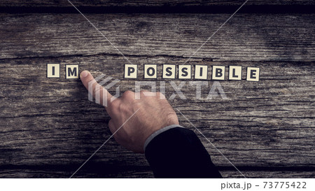 Businessman diving impossible letter tiles sign into possible 73775422