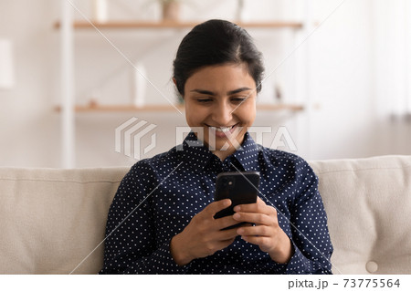 Content hindu woman reading email in convenient app on cell Content hindu woman reading email in convenient app on cell 73775564