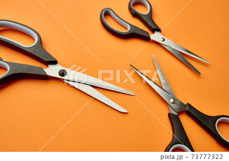 Scissors closeup, orange background, stationery Scissors closeup, orange background, stationery 73777322