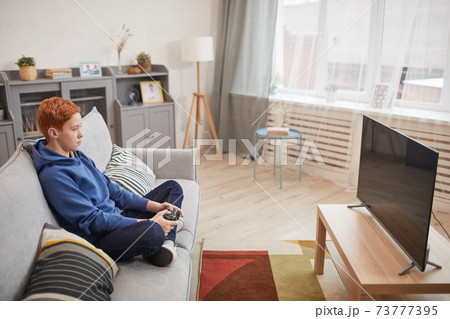 Bored Teenage Boy Playing Video Games Bored Teenage Boy Playing Video Games 73777395