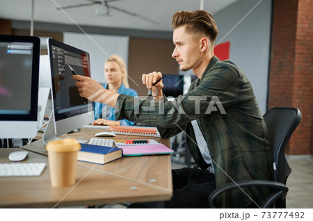 IT specialists group works at the tables in office IT specialists group works at the tables in office 73777492
