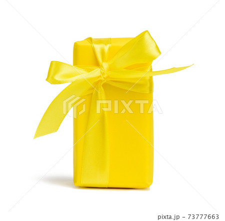 rectangular box with a gift wrapped in yellow paper and tied with a silk yellow ribbon rectangular box with a gift wrapped in yellow paper and tied with a silk yellow ribbon 73777663