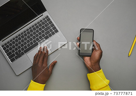 African Man Holding Phone at Workplace Top Down African Man Holding Phone at Workplace Top Down 73777871