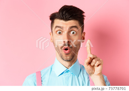 Close-up of excited guy pitching an idea, raising finger and saying suggestion, have a plan, standing on pink background 73778701