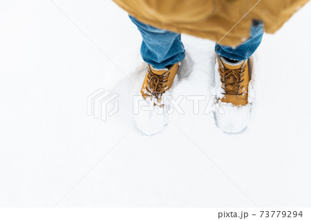 Boy's winter boots closeup on snowy background 73779294