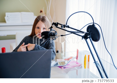 Blogger girl recording video broadcast with microphone about new cosmetic products. 73779533