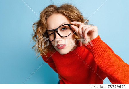 Curious woman in glasses looking at camera 73779692