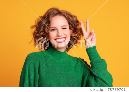 Happy young female gesturing V sign Happy young female gesturing V sign 73779701