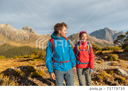 Hiking people walking living healthy outdoor active lifestyle doing hike at Routeburn Track. Multiethnic hikers with backpacks are tramping on Key Summit Track at Fiordland National Park, New Zealand 73779730