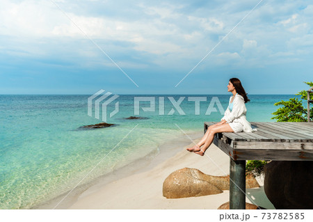 happy woman sitting on wooden bridge in the sea beach at Koh MunNork Island, Rayong, Thailand 73782585