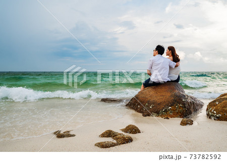 couple hugging on the rock of sea beach at Koh MunNork Island, Rayong, Thailand 73782592