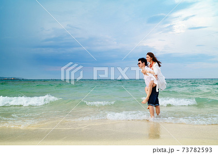 couple piggyback ride on the sea beach at Koh MunNork Island, Rayong, Thailand 73782593