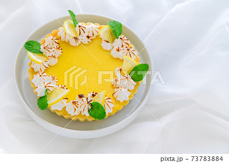 Lemon Tart citrus cake in white dish and white cloth background, Lemon Tart citrus cake in white dish and white cloth background, 73783884