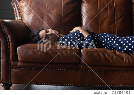 Tired young woman sleep on couch at home 73784401