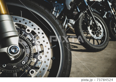 バイクツーリング 駐輪場に並ぶバイク 前輪に反射する陽射し　a-2 フィルム調 73784524