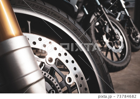 バイクツーリング 駐輪場に並ぶバイク 前輪に反射する陽射し b-3 フィルム調 暖色 バイクツーリング 駐輪場に並ぶバイク 前輪に反射する陽射し b-3 フィルム調 暖色 73784682
