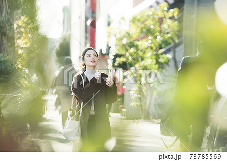 スマホで行き先を探す若い女性 73785569