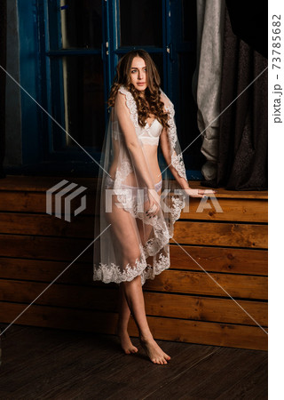 Morning of the bride. Portrait of a beautiful young female in a white underwear. 73785682