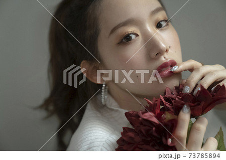花を持つ綺麗な女性のポートレート 73785894