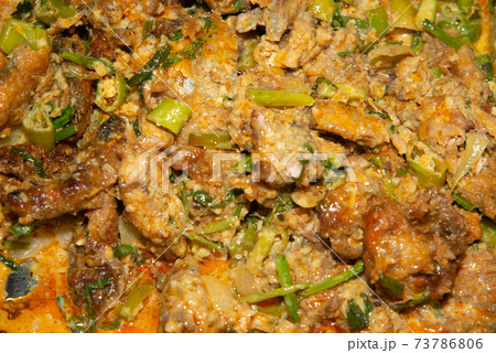 Spicy boiled mackerel in red curry sauce on a tray. 73786806