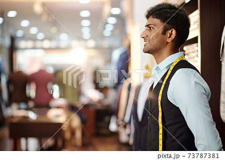 Tailor looking at bespoke suit Tailor looking at bespoke suit 73787381